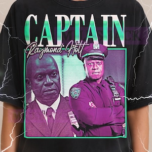 May include: Black t-shirt featuring a graphic of Captain Raymond Holt from Brooklyn Nine-Nine. The design includes two images of the character, the word "CAPTAIN", and the name "Raymond Holt".