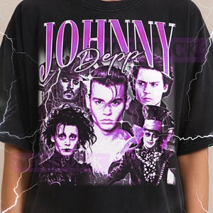 Könnte beinhalten: Schwarzes T-Shirt mit einer Grafik von Johnny Depp in verschiedenen Rollen und dem Namen "JOHNNY DEPP" in Lila. Das Milkshake-Logo befindet sich oben. Das Shirt ist ein Unisex 2XL.