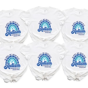 May include: Six white t-shirts with a blue and teal rainbow design and the words "In April We Wear Blue" and "Autism Awareness" printed on them. The shirts also have the text "#Team Alex".