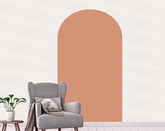 Puede incluir: Un adhesivo de pared grande en forma de arco de color terracota aplicado sobre una superficie plana. El arco presenta un acabado liso y mate con una parte superior redondeada, creando una forma geométrica definida en la pared clara.