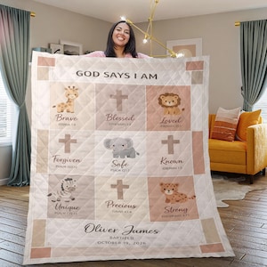 May include: A quilted blanket with the text "GOD SAYS I AM" and various inspirational words and animal illustrations. The blanket includes the name "Oliver James" and the date "OCTOBER 19, 2026". The color palette is soft, with beige, pink, and brown tones.