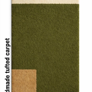 May include: Hand-tufted moss green rug with a cream-colored top section and a small tan square in the corner. The rug has the text "Hand Tufted Moss Green Rug" and "handmade tufted carpet". The brand logo "SC" is visible.