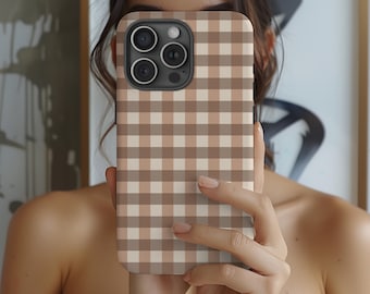 May include: A phone case with a brown and beige gingham pattern. The case has a camera module with three lenses and a flash. The case is held in front of a person.