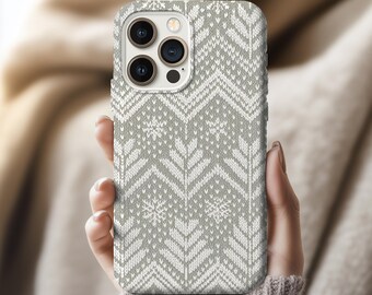 May include: A gray and white patterned phone case featuring a knit design with chevron and snowflake motifs. The case is designed to fit a smartphone with multiple camera lenses. The overall aesthetic is reminiscent of a winter sweater.