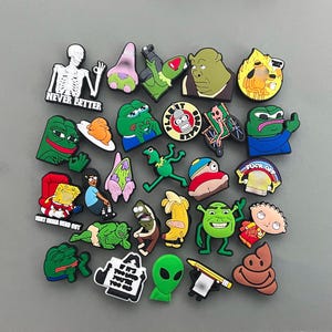 May include: A collection of colorful shoe charms featuring cartoon characters and memes. The charms include images of Shrek, SpongeBob, Pepe the Frog, and others. Some charms have text, including "NEVER BETTER" and "FUCK OFF".