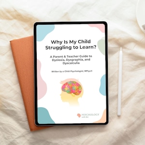 Pode incluir: Um tablet digital exibe a capa de um livro intitulado "Por que meu filho está com dificuldades para aprender?" com texto sobre dislexia, disgrafia e discalculia. Uma caneta branca e um livro laranja fechado estão ao lado do tablet. A capa do livro apresenta uma ilustração colorida do cérebro.
