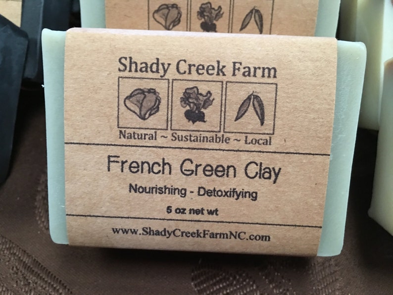 May include: A light green bar of soap with a brown paper label. The label reads "Shady Creek Farm" and "French Green Clay." The soap is 5 oz net weight. The label also states "Natural ~ Sustainable ~ Local."