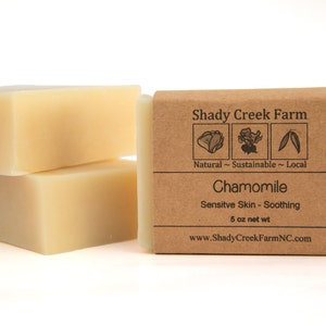 Peut inclure: Deux savons &agrave; la camomille naturels, durables et locaux de Shady Creek Farm. Le savon est con&ccedil;u pour les peaux sensibles et est apaisant. L'&eacute;tiquette est brune avec du texte blanc et des illustrations d'un chou, d'une fleur et d'une feuille. Le savon p&egrave;se 5 onces.