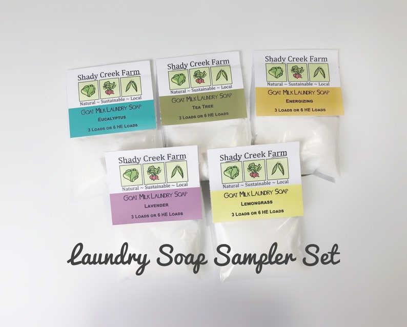 Peut inclure: Un ensemble de cinq petits sachets blancs contenant du savon &agrave; lessive au lait de ch&egrave;vre. Chaque sachet porte une &eacute;tiquette avec un logo vert et le texte "Shady Creek Farm" et "Savon &agrave; lessive au lait de ch&egrave;vre" avec un parfum diff&eacute;rent indiqu&eacute; en dessous. Les parfums sont Eucalyptus, Tea Tree, &Eacute;nergisant, Lavande et Citronnelle. Le texte "Ensemble d'&eacute;chantillons de savon &agrave; lessive" est &eacute;crit sous les sachets.
