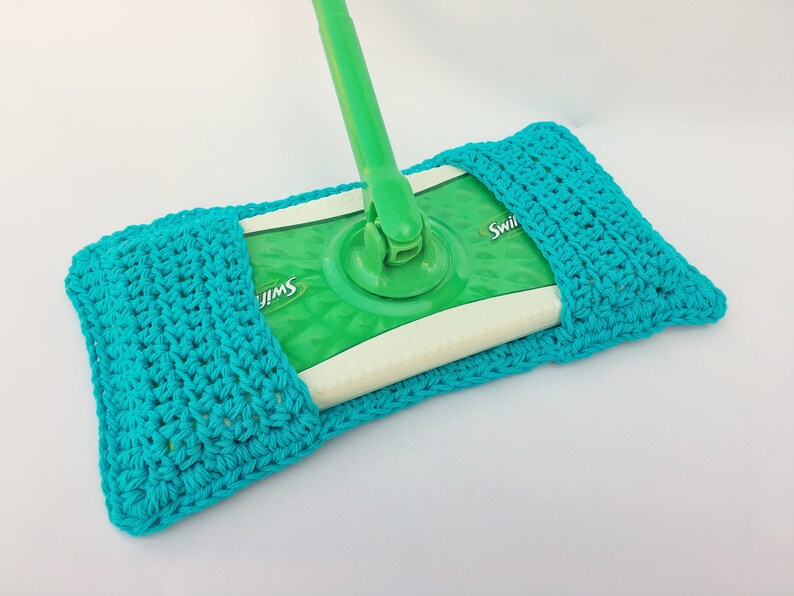 May include: A turquoise crocheted cover for a Swiffer Sweeper mop refill. The cover is made with a simple crochet stitch and has a pocket to hold the refill.