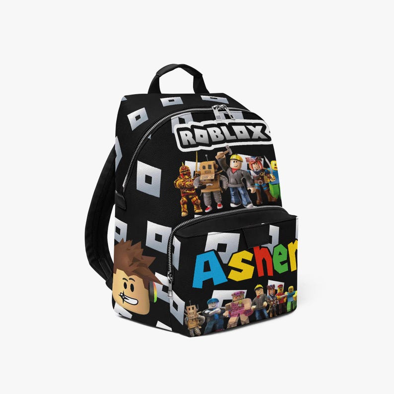 May include: Black backpack featuring the Roblox logo and characters, with the name "Asher" in colorful letters on the front pocket. The backpack has a repeating white square pattern.