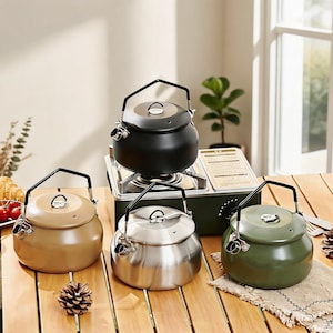May include: Four round camping kettles with black handles and lids, featuring a matte finish in black, tan, silver, and olive green. Each kettle has a small spout and a circular lid knob. The black kettle sits on a portable gas stove.