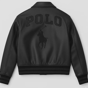 Puede incluir: Chaqueta bomber negra con la palabra "POLO" en la espalda en letras en relieve. Una silueta negra de un jugador de polo a caballo está debajo de la palabra "POLO". La chaqueta tiene un dobladillo y puños acanalados.