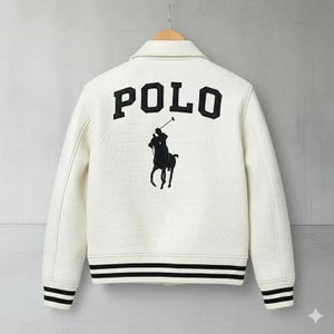 Może przedstawiać: Kremowa kurtka z czarnymi akcentami. Z tyłu znajduje się napis "POLO" pogrubionymi czarnymi literami nad czarną sylwetką gracza w polo na koniu. Kurtka ma wzorzystą fakturę oraz czarno-białe paski na mankietach i u dołu.