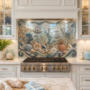 Op de afbeelding: Een decoratieve keukenachterwand met een reliëfsculptuur van een onderwaterscène met koraal, schelpen, een zeester en vissen in blauwe, beige en oranje tinten, geplaatst achter een roestvrijstalen gasfornuis met zwarte branders.
