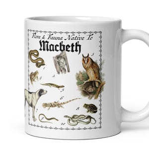 May include: A white ceramic mug featuring a black-and-white illustration titled Flora & Fauna Native To Macbeth. The design includes numbered drawings of various animals, including a snake, bat, owl, dog, and lizards, enclosed in a decorative border.