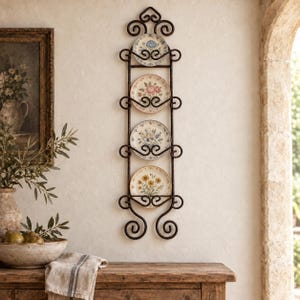 May include: A vertical black metal wall rack with scrollwork details holding four round ceramic plates. Each plate features a unique floral pattern with colors including blue, pink, yellow, and green. The rack has a symmetrical design.