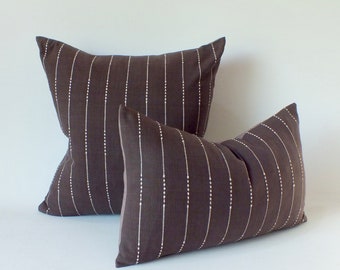 May include: Two decorative throw pillows with a brown and white striped pattern. The pillows are made of a soft, textured fabric and have a subtle sheen.