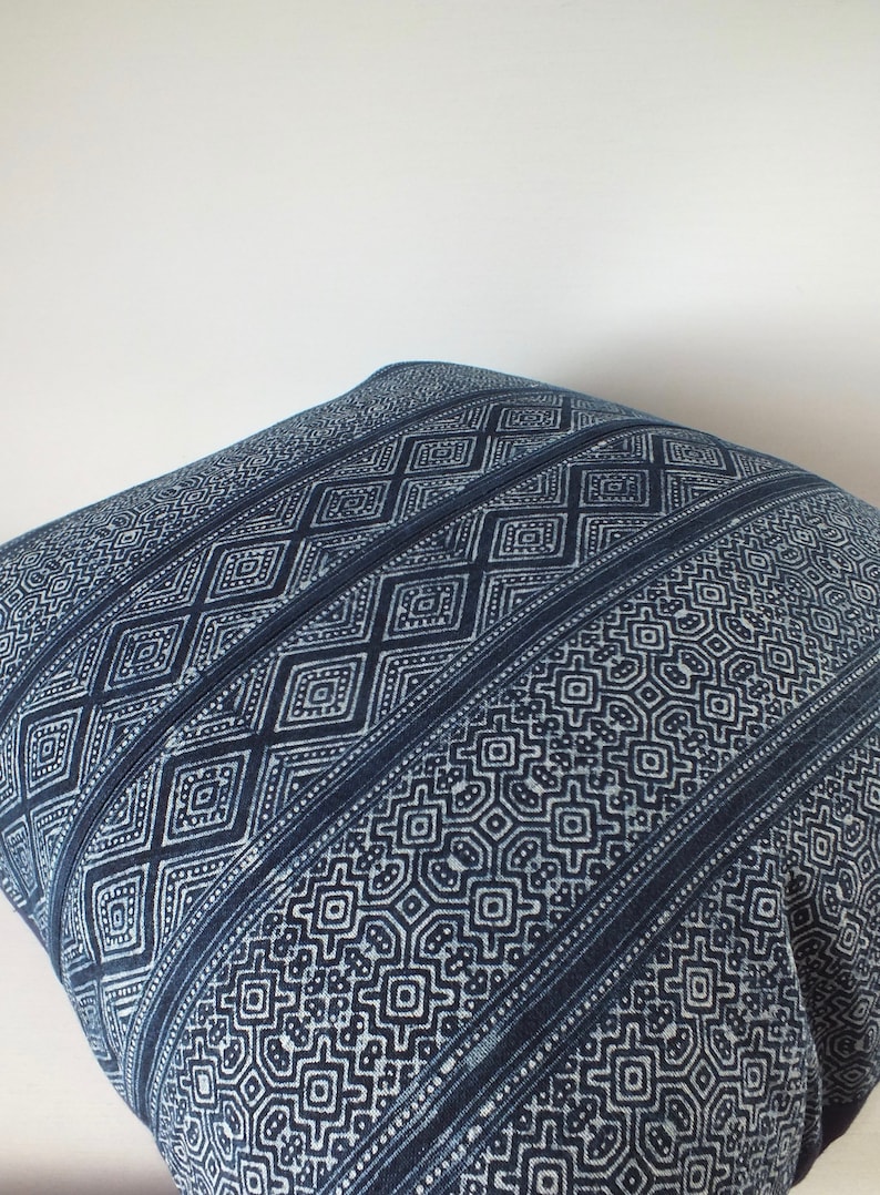 May include: A blue and white patterned cushion cover with a geometric design. The cushion cover is made of a soft, woven fabric.