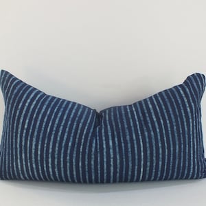 May include: A blue and white striped lumbar pillow with a subtle sheen. The pillow is made of a soft, textured fabric.