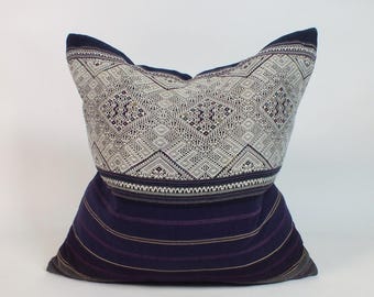 May include: Decorative pillow with a geometric pattern in shades of gray and white on the top section. The bottom section is a deep navy blue with horizontal stripes. The pillow has a soft, inviting appearance, suitable for home decor.