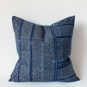 May include: A blue and white patterned throw pillow with a geometric design.