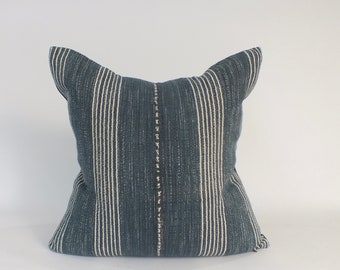 May include: A blue and white striped throw pillow with a white stitched seam down the center.