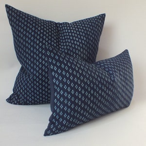 May include: Two blue throw cushions with a white geometric pattern. The cushions are made of a soft, textured fabric.
