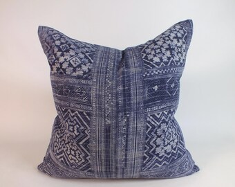 May include: A blue and white patterned throw pillow with a geometric design. The pillow is made of a soft, textured fabric.