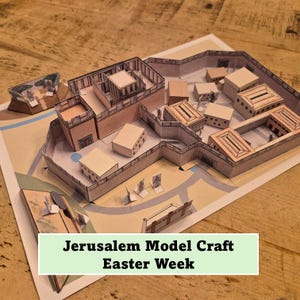 May include: A paper model of Jerusalem, featuring detailed structures and walls. The model is set on a map-like base, with the text "Jerusalem Model Craft Easter Week" displayed at the bottom. The model is made of tan and brown paper.