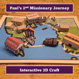 Puede incluir: Un mapa artesanal de papel que representa el segundo viaje misionero de Pablo, con modelos 3D de ciudades antiguas como Corinto, Éfeso y Atenas. El mapa está sobre un fondo azul con una ruta marcada por flechas. El texto en la parte superior dice "Paul's 2nd Missionary Journey".