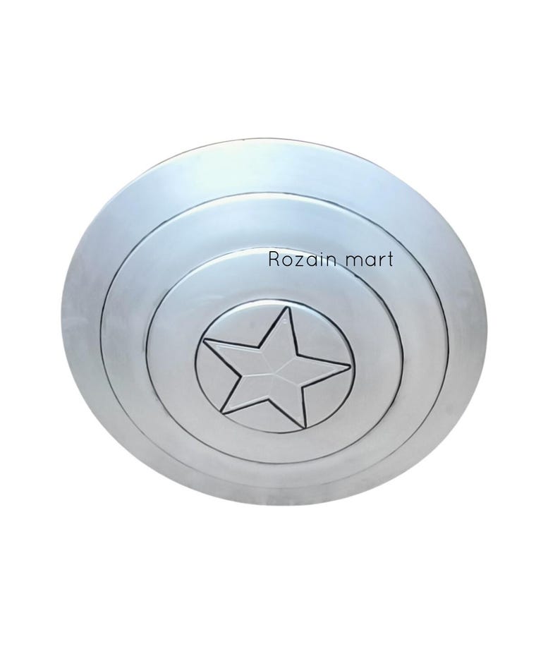 May include: A silver-colored, circular shield with concentric rings and a central star design. The shield has a metallic finish and the text "Rozain mart" is visible on the surface.