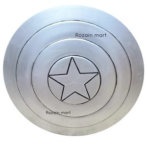 May include: A silver-colored, circular shield with concentric rings and a central five-pointed star. The shield has a metallic sheen and a raised star design. The text "Rozain mart" is printed on the shield.