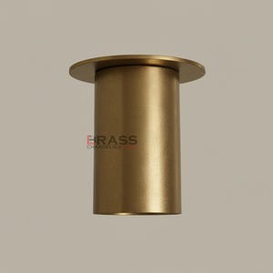 May include: A cylindrical brass chandelier component with a circular top. The component has a brushed finish and the text "BRASS CHANDELIER" is printed on the side. The overall design is simple and modern.