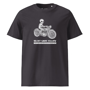 Può includere: T-shirt grigio scuro con grafica bianca di un alieno su una moto d'epoca. Il testo "SILENT GRAY FELLOW" e "1911 Harley-Davidson Model 8A" sono stampati sotto l'illustrazione.