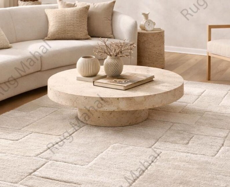 Ivory textured geometric area rug styled in a modern minimalist living room with neutral furniture.