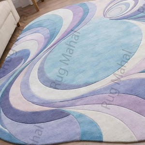 Abstract swirl shaped pastel area rug in blue, purple and white colors styled in a modern living room interior