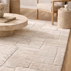 Ivory textured geometric area rug styled in a modern minimalist living room with neutral furniture.