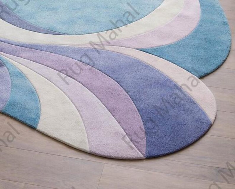 Abstract swirl shaped pastel area rug in blue, purple and white colors styled in a modern living room interior