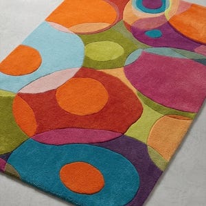 Angled view of colorful rug highlighting layered shapes and plush textured surface.