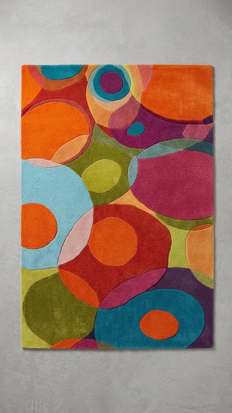 Top view of multicolor abstract rug with organic shapes and bold color blocks on a clean background.