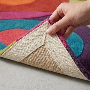 Folded corner showing thick plush pile, backing, and rug flexibility.