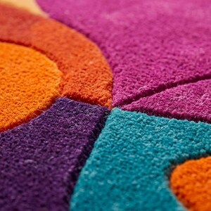 Close-up of rug surface showing layered shapes and carved texture details.