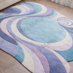 Abstract swirl shaped pastel area rug in blue, purple and white colors styled in a modern living room interior