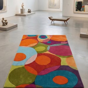 Abstract colorful rug displayed like a modern art piece on a gallery-style floor.