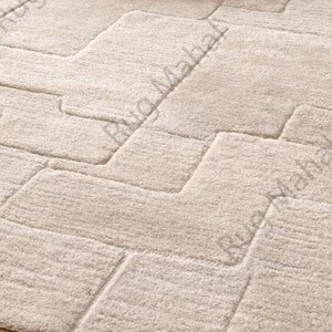Ivory textured geometric area rug styled in a modern minimalist living room with neutral furniture.