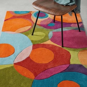 Cozy reading corner with colorful rug under chair and side table.
