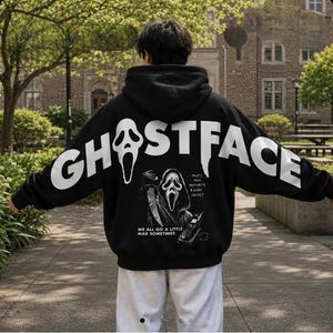 May include: A black hooded sweatshirt featuring the white text GHOSTFACE across the back. Below the text is a graphic of the Ghostface character holding a knife and a telephone, with the text WHAT'S YOUR FAVOURITE SCARY MOVIE? and WE ALL GO A LITTLE MAD SOMETIMES.