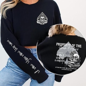 Op de afbeelding: Zwart sweatshirt met een wit schoppenontwerp met een schedel en tekst. De linkermouw heeft de tekst "I vow. You vow. We vow." De achterkant van het sweatshirt heeft een groter ontwerp met de tekst "Property of the Spade Brothers."