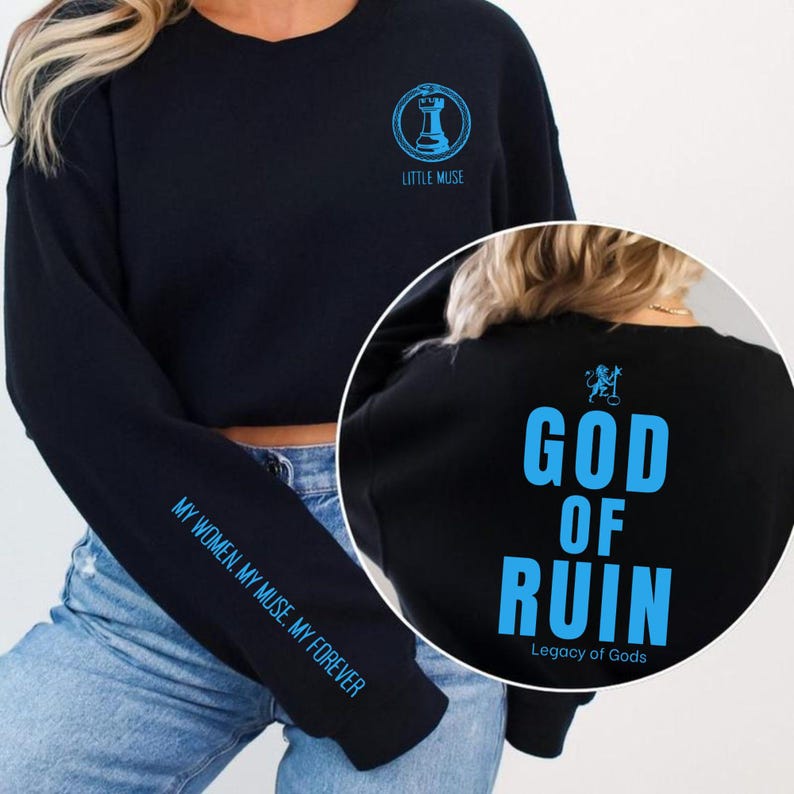 May include: Black sweatshirt with blue text and graphics. The front features a chess piece graphic and the words "LITTLE MUSE". The sleeve reads "MY WOMEN. MY MUSE. MY FOREVER". The back displays "GOD OF RUIN" and "Legacy of Gods".